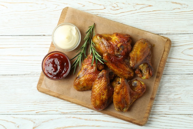 Concept de plats savoureux avec des ailes de poulet cuit au four sur fond en bois blanc