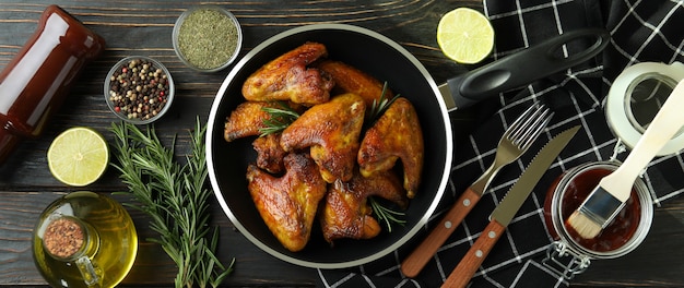 Concept de plats savoureux avec des ailes de poulet cuit au four sur fond de bois