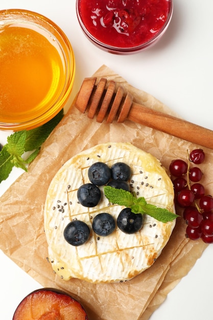 Concept de plats savoureux avec camembert grillé sur fond blanc.