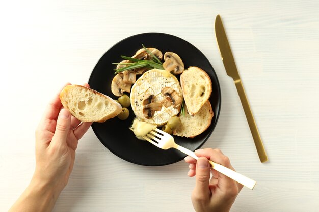 Concept de plats savoureux avec camembert grillé sur fond de bois blanc.