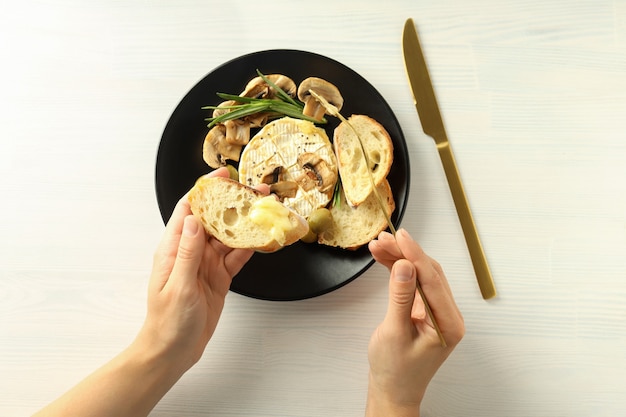 Concept de plats savoureux avec camembert grillé sur fond de bois blanc.