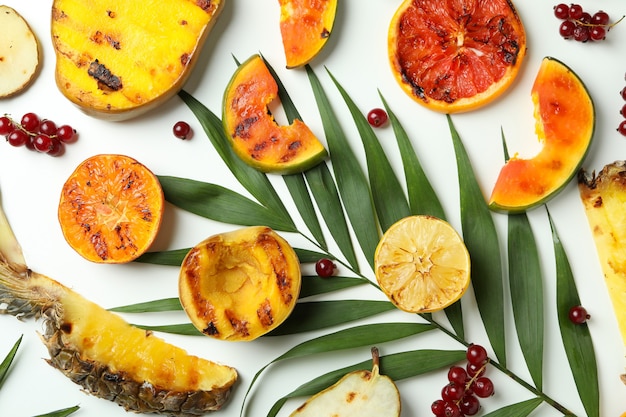 Concept de plats savoureux avec des fruits grillés sur fond blanc.