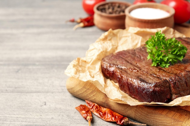 Concept de plats savoureux avec steak de boeuf sur fond de bois gris