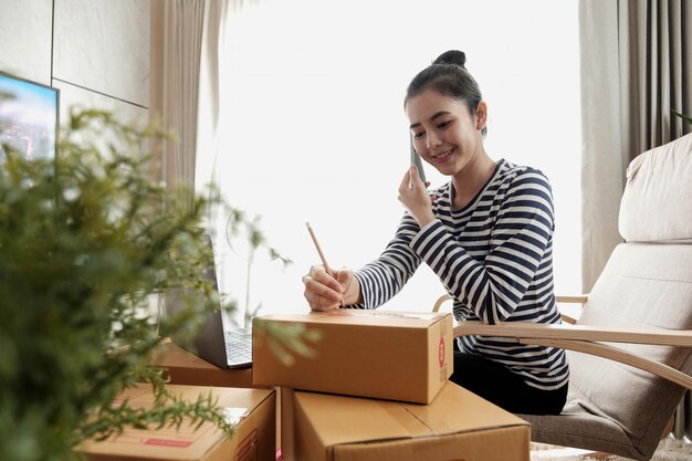 Photo concept de pme de démarrage d'entreprise. jeune entrepreneur en démarrage propriétaire d'une petite entreprise travaillant à domicile, situation d'emballage et de livraison. femmes, propriétaires d'une petite entreprise d'emballage de produits dans des boîtes.