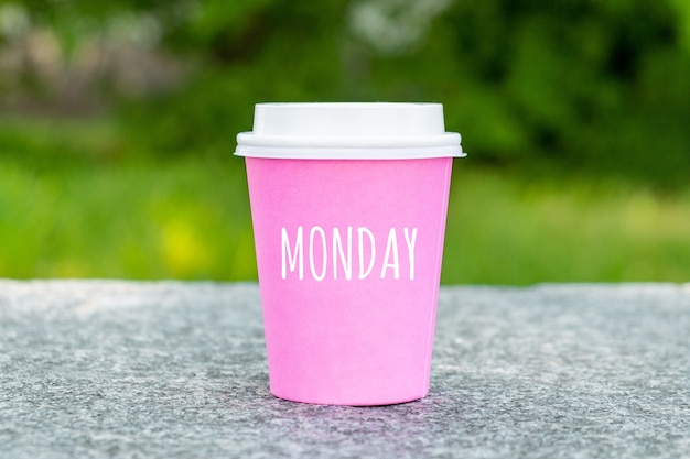 Concept pour le début du lundi sur une tasse de café jetable.