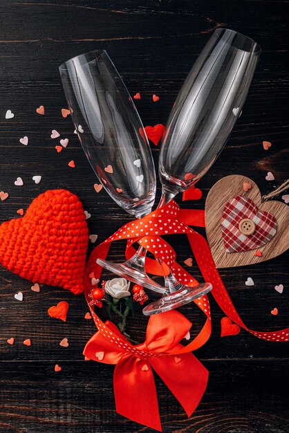 Concept pour la Saint-Valentin. dîner de gala pour deux avec deux coupes de champagne. fond avec les attributs de la célébration de la Saint-Valentin. couleur rouge dominante. tourné en studio, vue de dessus.