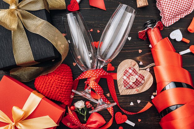 Concept pour la Saint-Valentin. dîner de gala pour deux avec deux coupes de champagne. fond avec les attributs de la célébration de la Saint-Valentin. couleur rouge dominante. tourné en studio, vue de dessus.