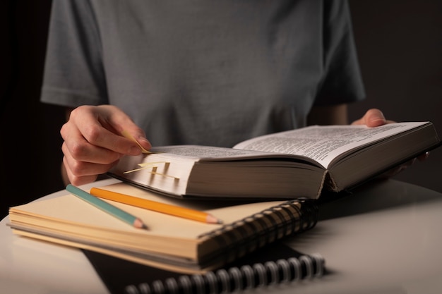 Concept de préparation pour examen, apprentissage, étude et éducation la nuit à table avec de la papeterie.