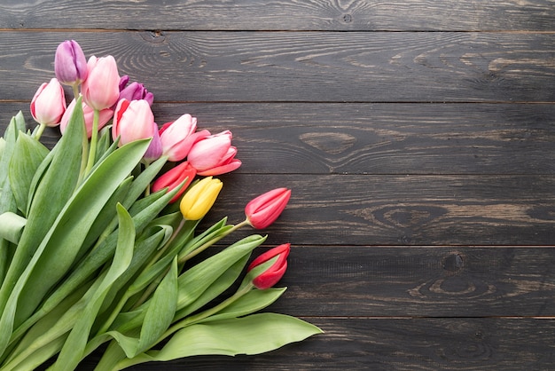 Concept de printemps. Bouquet de tulipes sur fond de bois noir