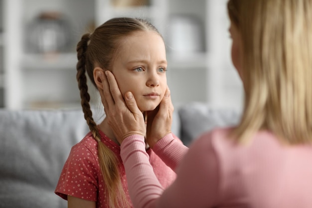 Concept de problèmes d'enfance jeune mère réconfortant sa petite fille triste à la maison