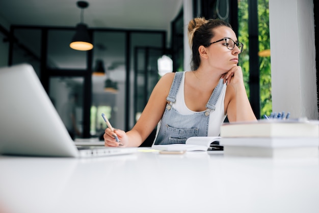 Photo concept de procrastination. fille regardant ailleurs pendant ses études.