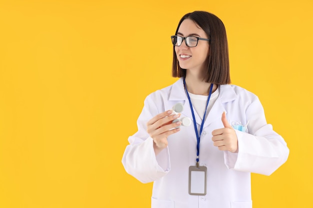 Concept de profession jeune femme médecin sur fond jaune