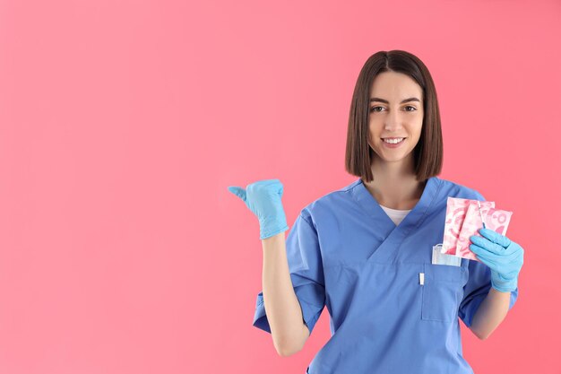 Concept de profession jeune femme médecin sur fond rose