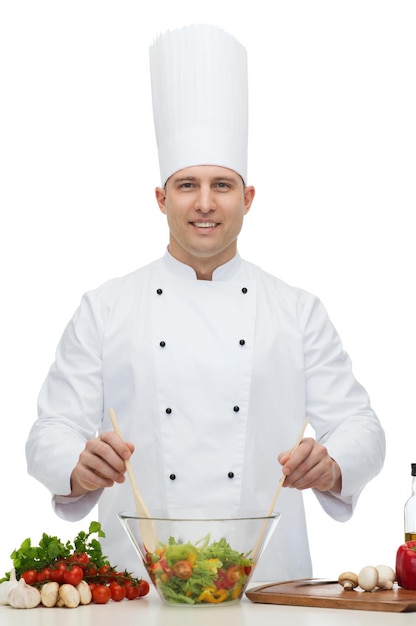 concept de profession, végétarien, nourriture et personnes - chef masculin heureux cuisinant une salade de légumes