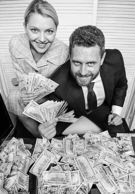 Photo concept de profit énorme succès financier homme d'affaires et femme secrétaire avec pile de billets en dollars concept de profit et de richesse