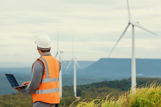 Concept progressif d'ingénieur travaillant dans le parc éolien au sommet de la montagne