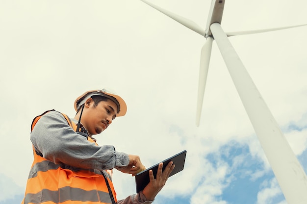 Concept progressif d'ingénieur travaillant dans le parc éolien au sommet de la montagne