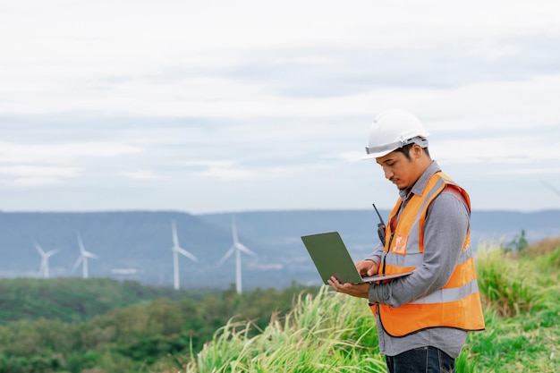 Concept progressif d'ingénieur travaillant dans le parc éolien au sommet de la montagne