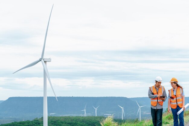 Concept progressif d'ingénieurs travaillant dans le parc éolien au sommet de la montagne