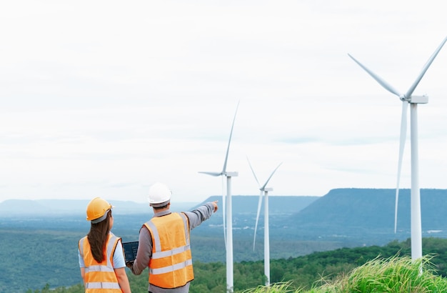 Concept progressif d'ingénieurs travaillant dans le parc éolien au sommet de la montagne