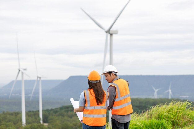 Concept progressif d'ingénieurs travaillant dans le parc éolien au sommet de la montagne