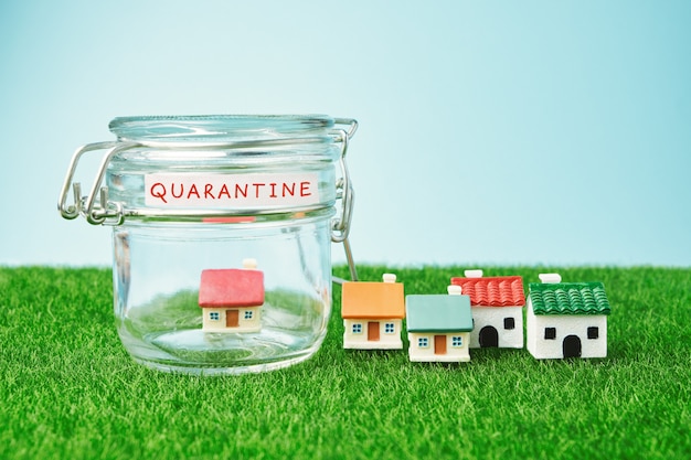 Concept de quarantaine de coronavirus. Petite maison à l'intérieur d'un bocal en verre et inscription Quarantaine