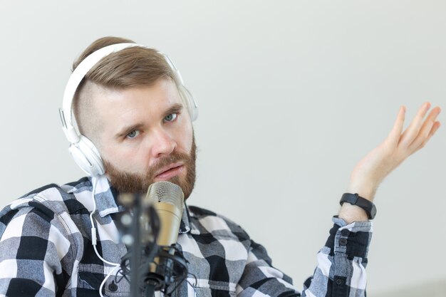 Concept radio et DJ - Homme avec microphone et gros casque fonctionne