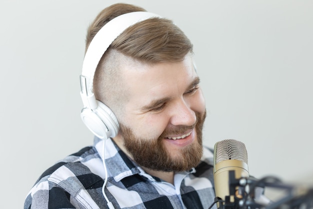 Concept radio et DJ - homme avec microphone et gros casque sourit