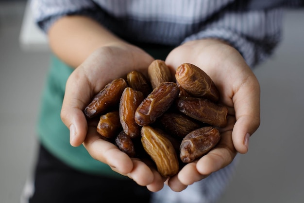 Concept de ramadan kareem Poignée de dates en main sur fond flou