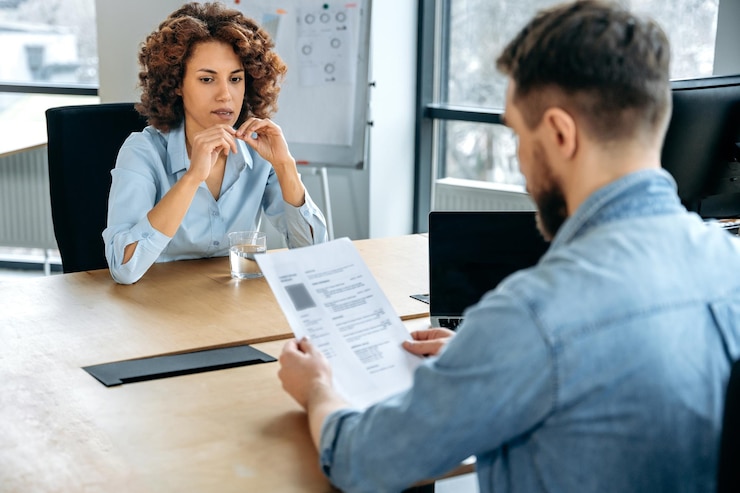 Photo concept de recrutement femme afro-américaine est interviewée pour un nouvel emploi dans le bureau stressée anxieuse inquiète le directeur de l'embauche étudie son cv pose des questions