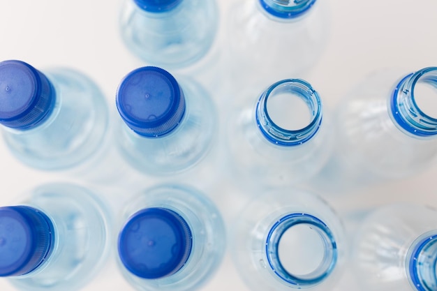 concept de recyclage, d'alimentation saine et de stockage des aliments - gros plan de bouteilles en plastique avec de l'eau potable pure sur la table