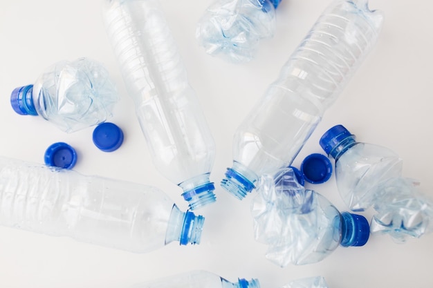 concept de recyclage, de réutilisation, d'élimination des déchets, d'environnement et d'écologie - gros plan de bouteilles d'eau en plastique vides et écrasées sur la table