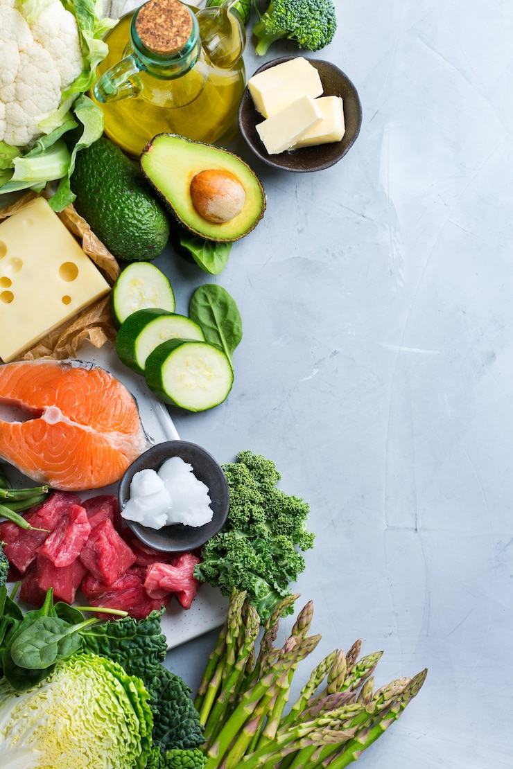 Photo concept de régime alimentaire équilibré céto. assortiment d'ingrédients cétogènes sains à faible teneur en glucides pour cuisiner sur une table de cuisine. légumes verts, viande, saumon, fromage, œufs. arrière-plan de la vue de dessus