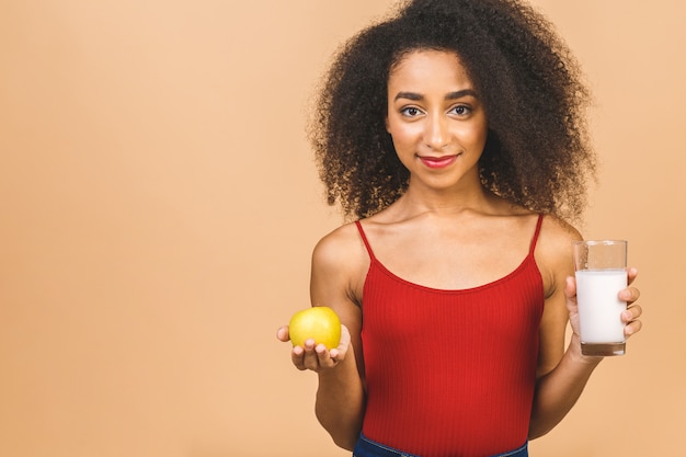 Concept de régime. Belle jeune femme mangeant du yaourt et de la pomme verte comme petit déjeuner sain ou collation.