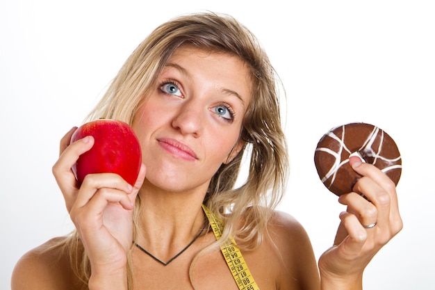 Concept de régime: femme en difficulté entre pomme ou beignets