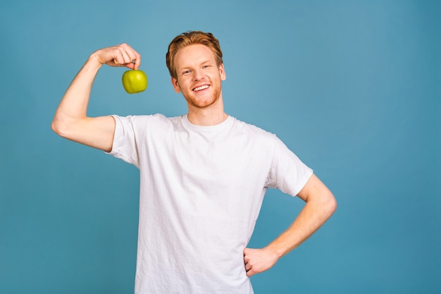 concept de régime et mode de vie sain. joyeux beau jeune homme mangeant une pomme,