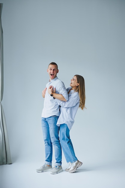 Concept de relation photo d'un couple heureux en chemises blanches et jeans sur fond blanc Heureux jeune couple