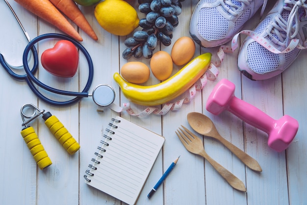 Concept de remise en forme avec équipement d'exercice sur fond en bois blanc.