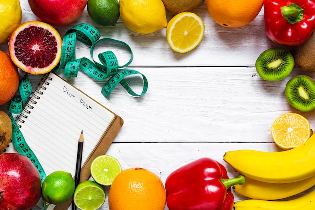 Concept de remise en forme avec des fruits, des légumes, un ruban à mesurer et un livre de texte