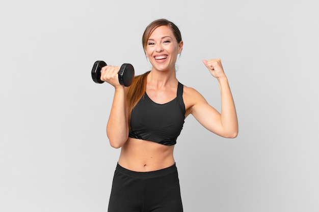 Concept de remise en forme de jeune jolie femme et soulevant un haltère