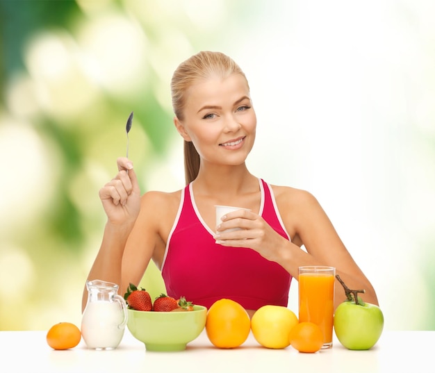 concept de remise en forme, de soins de santé et de régime - jeune femme souriante mangeant un petit-déjeuner sain