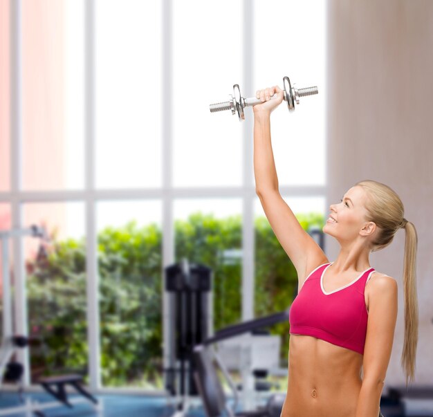 concept de remise en forme, de soins de santé et de régime - jeune femme sportive avec haltère en acier lourd