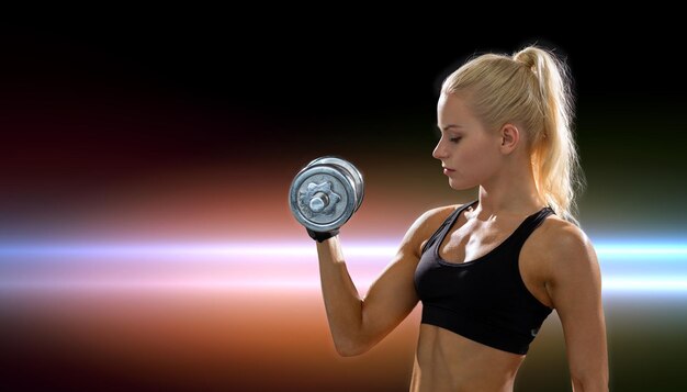 concept de remise en forme, de soins de santé et de régime - jeune femme sportive avec haltère en acier lourd