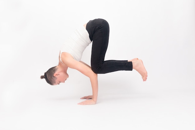 Concept de remise en forme, sport, entraînement et mode de vie - Jeune femme faisant du yoga. Portrait de jeune fille belle en vêtements de sport blancs faisant du yoga. Femme faisant des exercices d'étirement