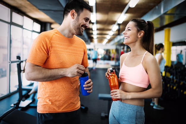 Concept de remise en forme, sport, exercice et mode de vie sain - groupe de personnes heureuses en salle de sport