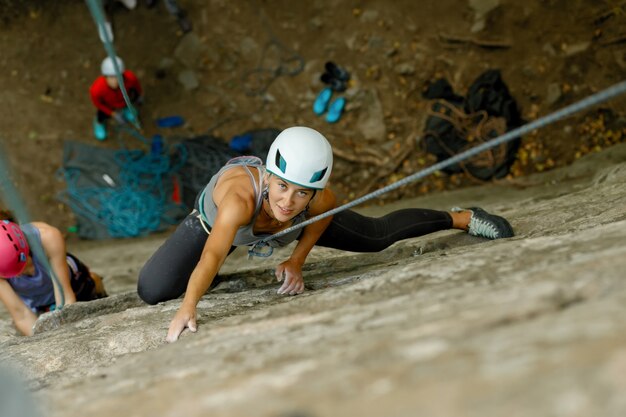 Concept de remise en forme, de sport extrême et de mode de vie sain - Le grimpeur surmonte une voie d'escalade difficile. Une fille escalade un rocher. Femme engagée dans le sport extrême. Passe-temps extrême.