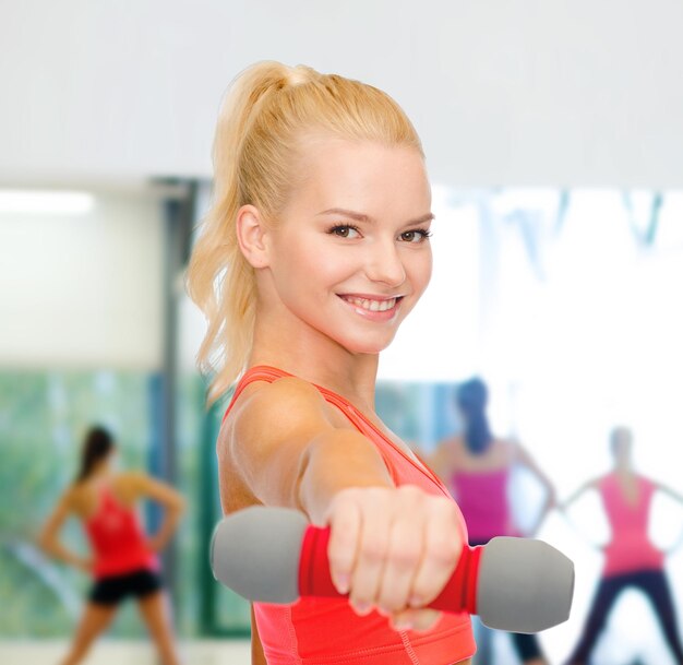 concept de remise en forme, de sport et de régime - belle femme sportive souriante avec haltère