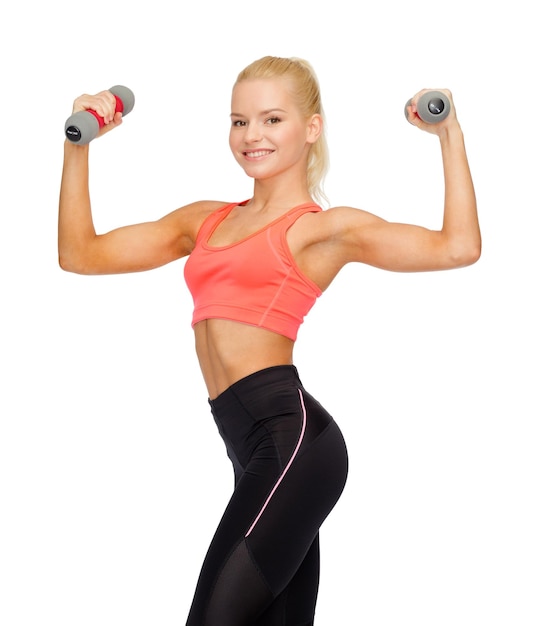 concept de remise en forme, de sport et de régime - belle femme sportive souriante avec des haltères