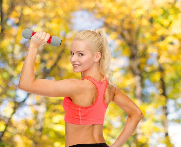 concept de remise en forme, de sport et de régime - jeune femme sportive avec haltère léger