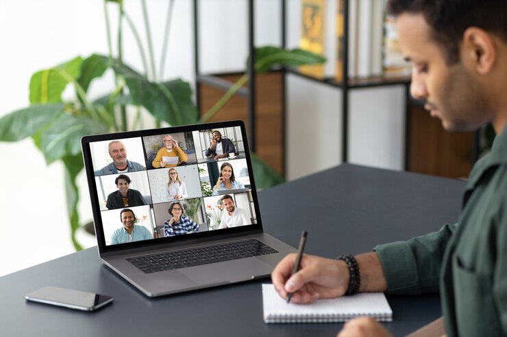 Photo concept de remue-méninges de groupe, un employé indien utilise un ordinateur portable pour une réunion en ligne avec divers collègues multiraciaux assis sur le lieu de travail